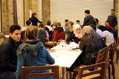 Mehrere Menschen unterschiedlicher Herkunft in einem Café