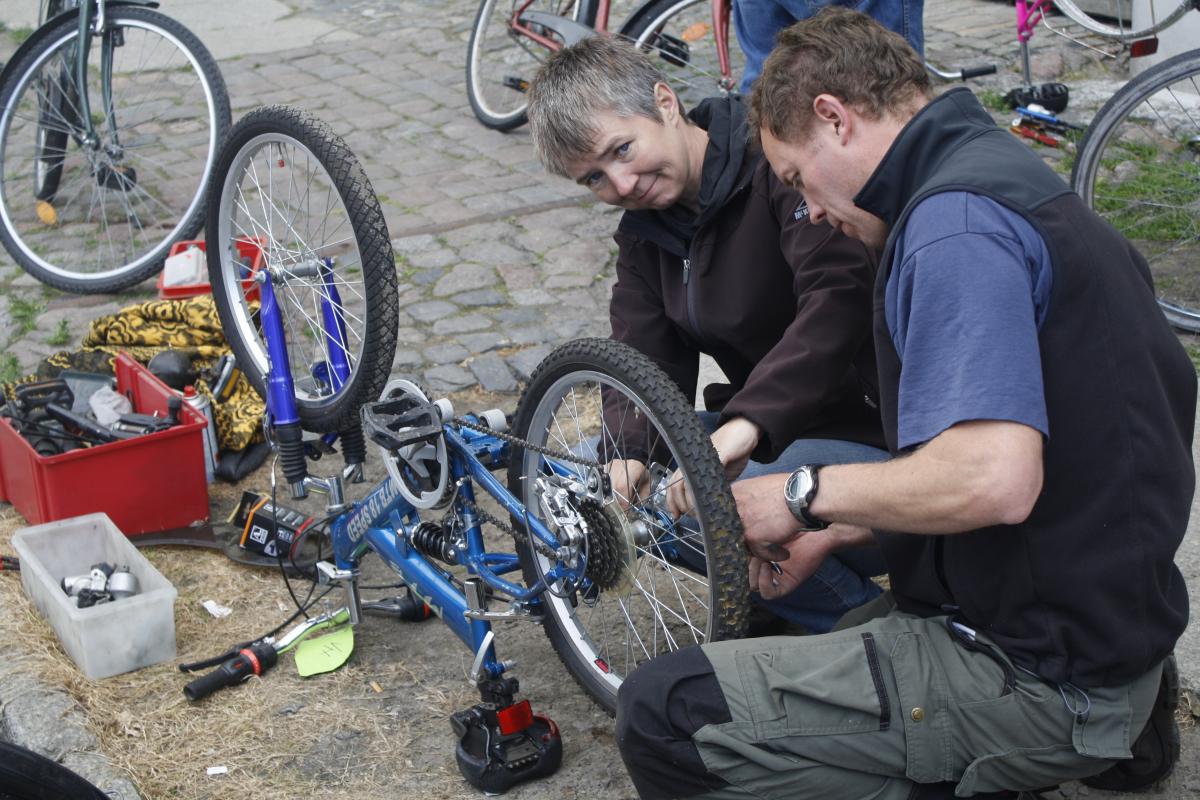 Eine Frau und ein Mann reparieren Fahrräder