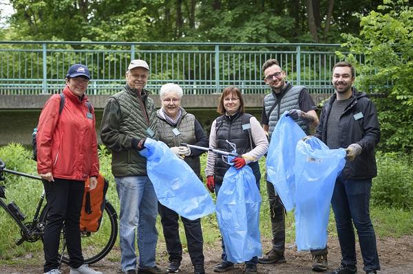Müll sammeln eine Gruppe von Menschen mit Müllbeuteln am Kanal