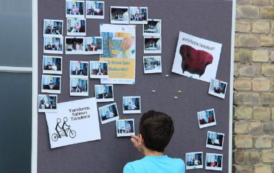 Ein Junge steht vor einer Pinnwand mit Fotos